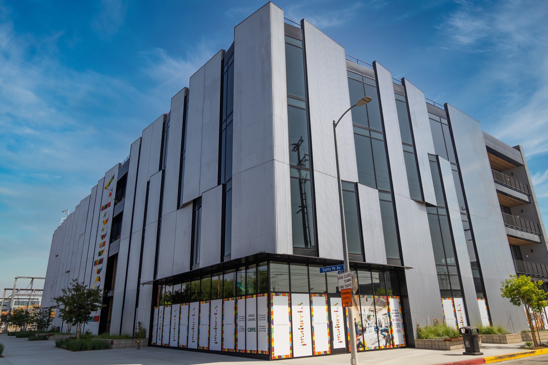 Street level perspective of a finished modern building with vertical facade panels