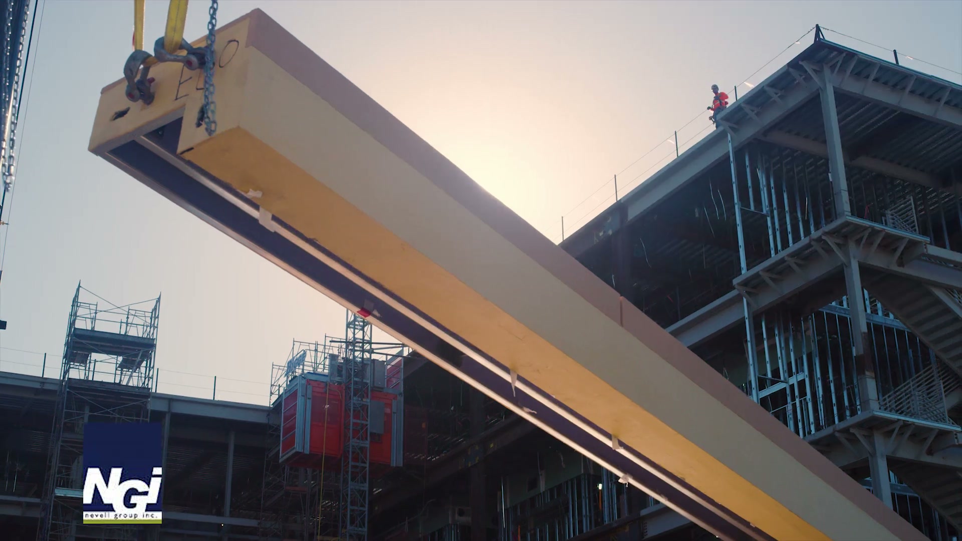 A crane lifting a large wall panel into position on a construction site